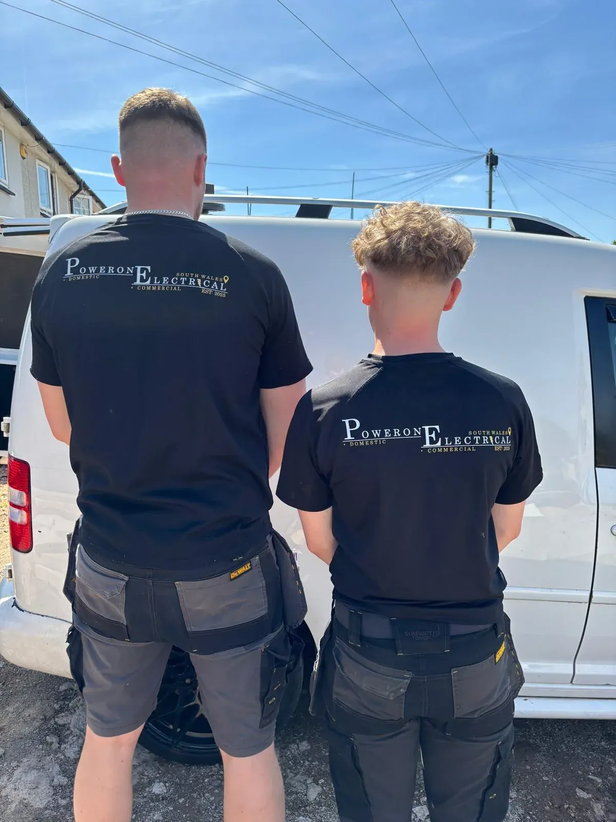 Dan Payne and apprentice Jack in PowerOn Electrical shirts beside the company van