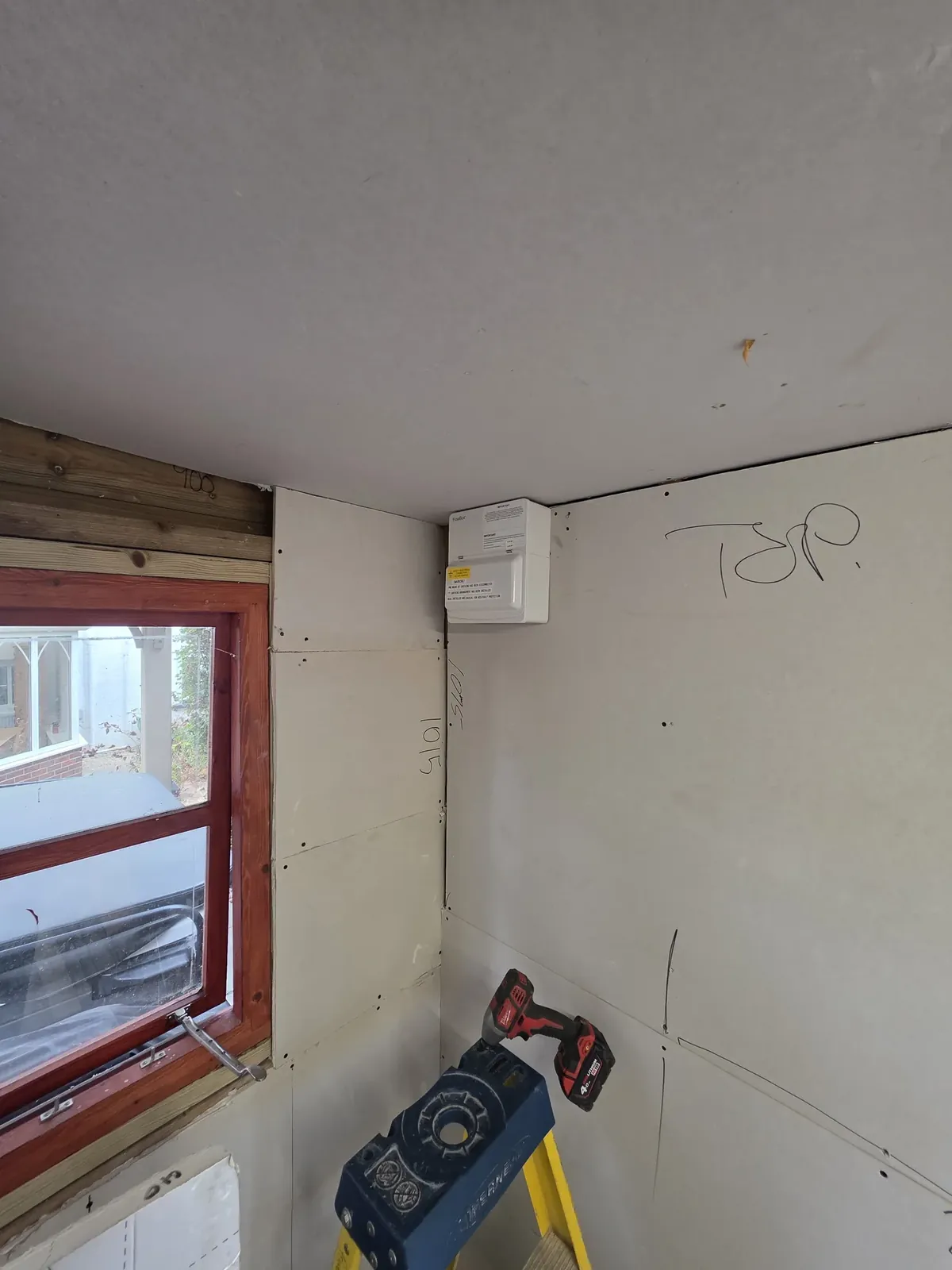Consumer unit mounted high on new plasterboard during a refurbishment