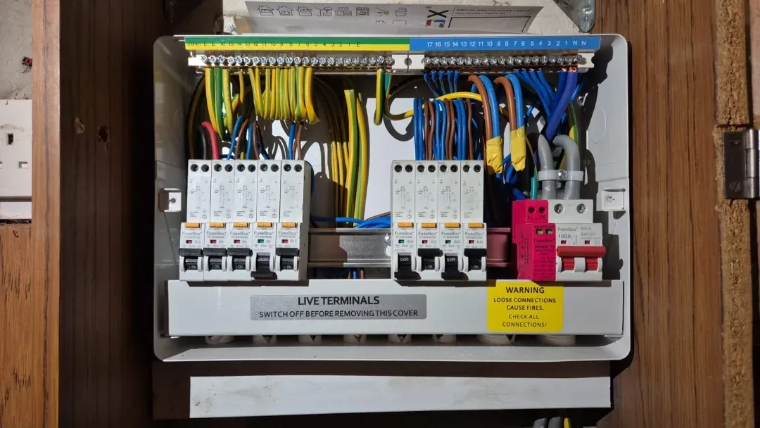 RCBO consumer unit with surge protection device, cover off, on a timber backboard