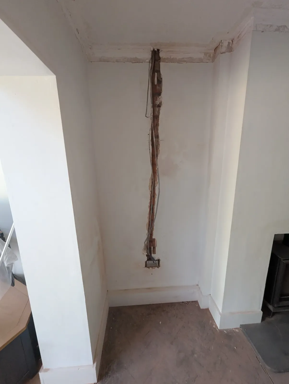 Alcove wall chased out with old cables being replaced during a rewire