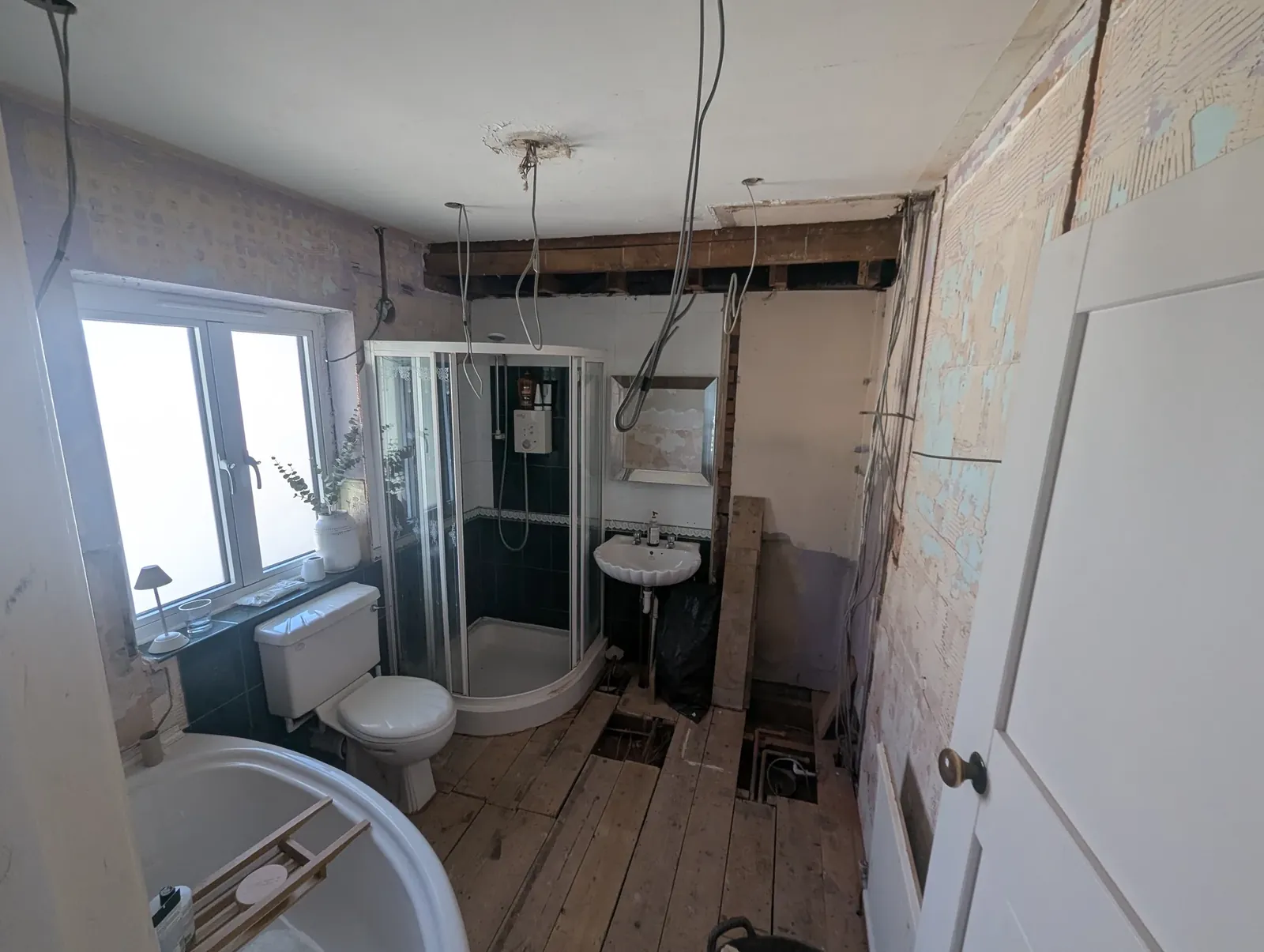 Bathroom stripped out with floorboards lifted and ceiling cables ready for first fix