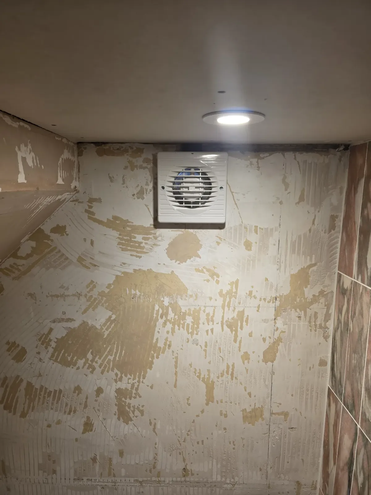 Extractor fan and LED downlight installed in a bathroom during a refurbishment