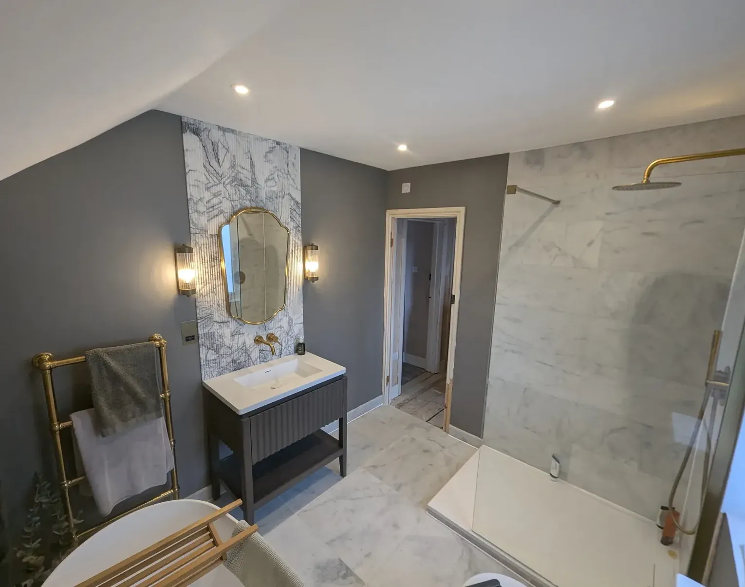 Finished bathroom vanity with brass wall lights either side of the mirror