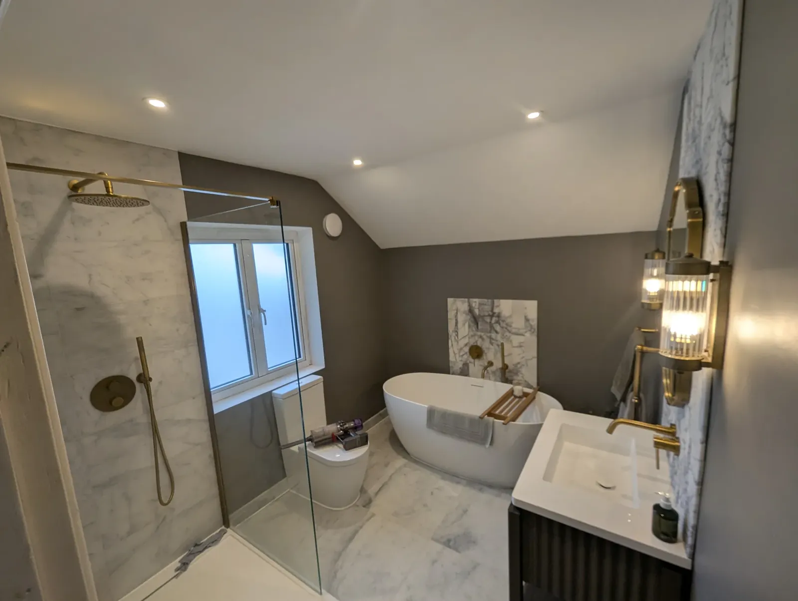 Freestanding bath and walk-in shower under newly fitted downlights
